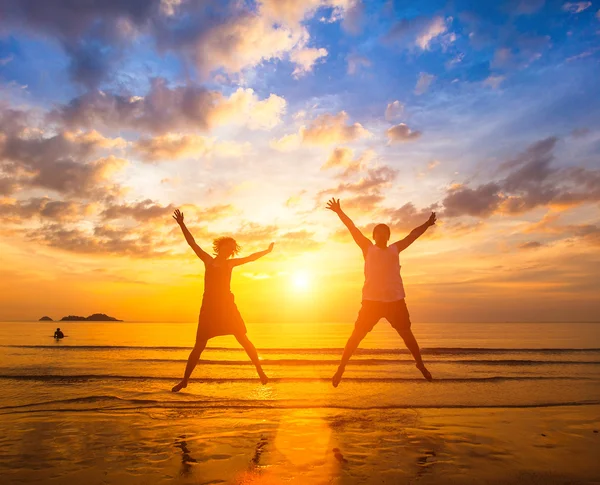 Paar springen op het strand oceaan — Stockfoto