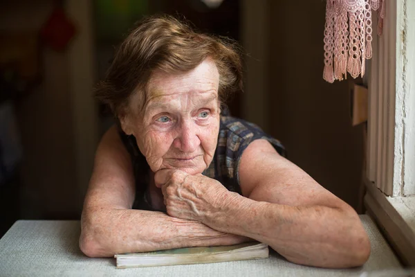 Vieja pensativa con un libro — Foto de Stock