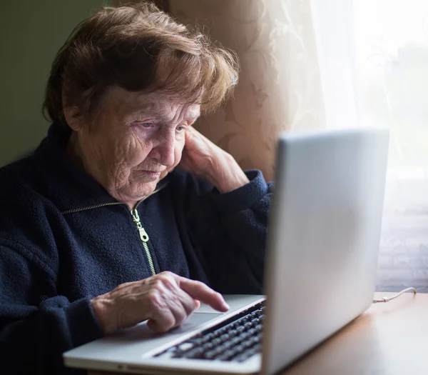 Gammal kvinna att skriva på laptop — Stockfoto