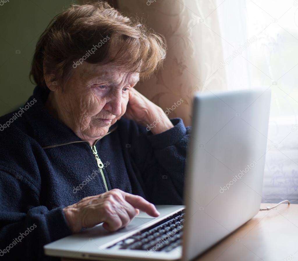 Old woman typing on laptop