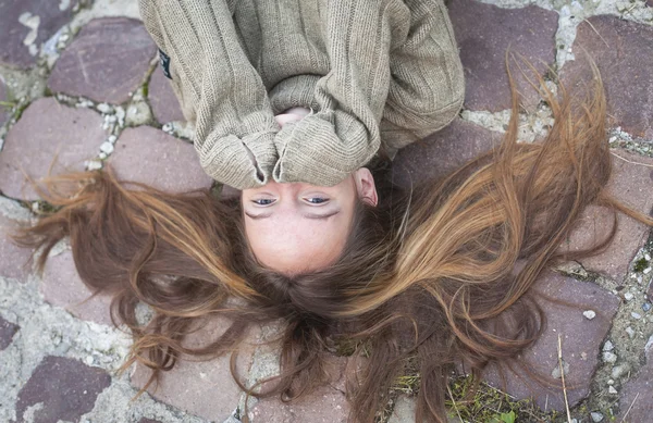 Flicka liggande på trottoaren — Stockfoto