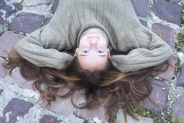 Menina deitada nos paralelepípedos — Fotografia de Stock