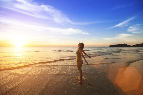 Frau steht am Strand des Ozeans — Stockfoto