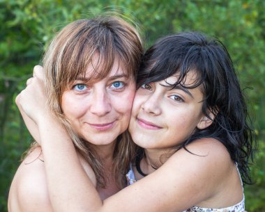 Anne kızını kucaklıyor.