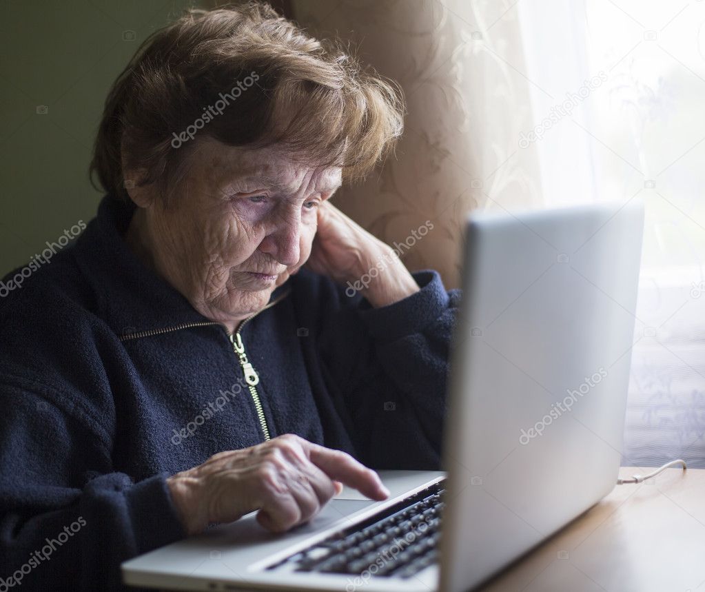 Old woman works on laptop