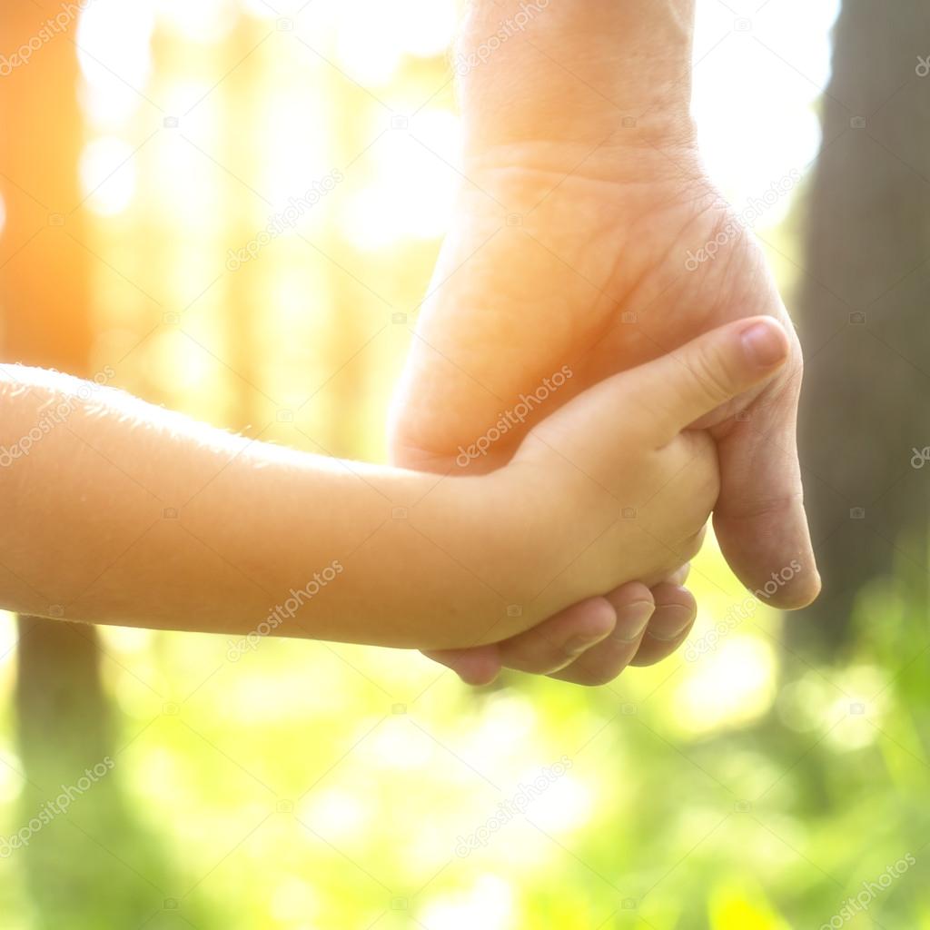 Adult holding child's hand