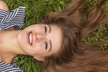 Kız çimenlerde yatıyor.