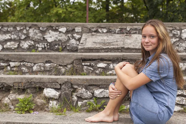 Girl sitting on the stone steps — Stock Photo, Image