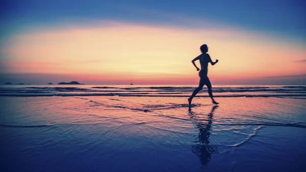 Running vrouw op het strand — Stockfoto