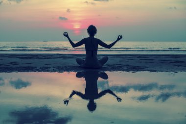 Kız Sahilde meditasyon yapıyor