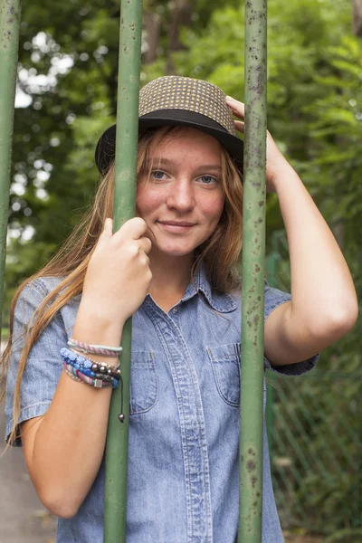 Girl standing behind the bars — Stock Photo, Image