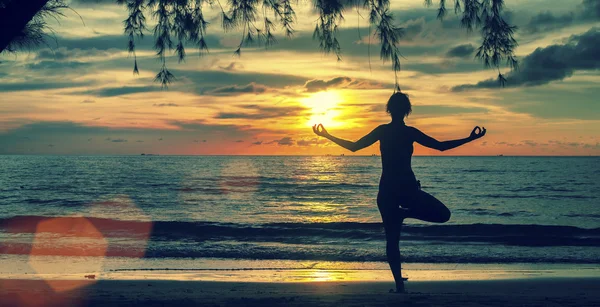 Silhouette Junge Frau praktiziert Yoga — Stockfoto