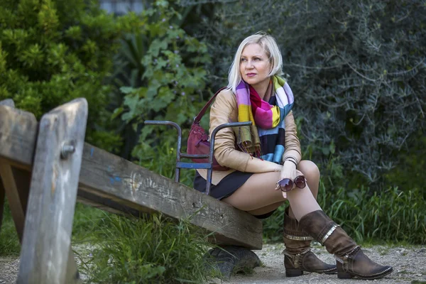 Jonge vrouw zitten in het park. — Stockfoto