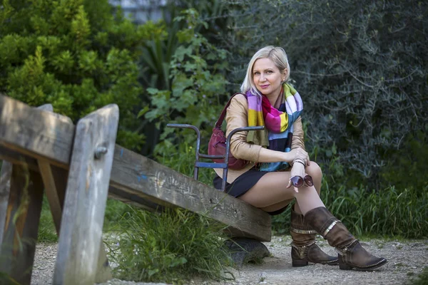 Junge Frau sitzt im Park — Stockfoto