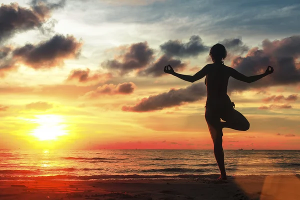 Silhouette di donna in piedi a posa yoga — Foto Stock