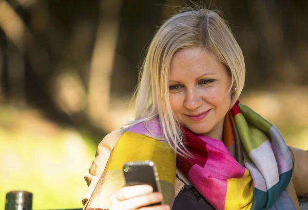 Ung kvinna sitter med smartphone — Stockfoto