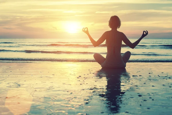 Silueta femenina en postura de meditación de yoga —  Fotos de Stock