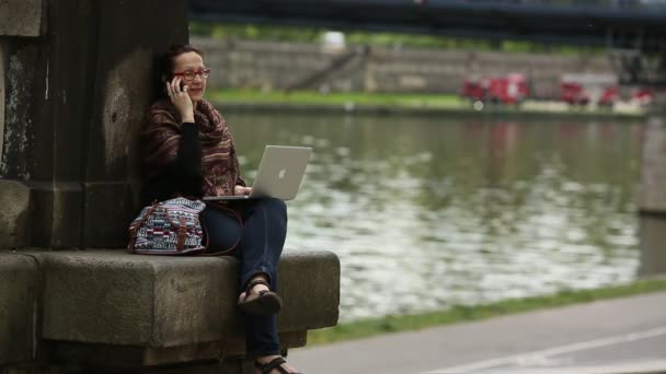 Νεαρή γυναίκα κάθεται με φορητό υπολογιστή — Αρχείο Βίντεο