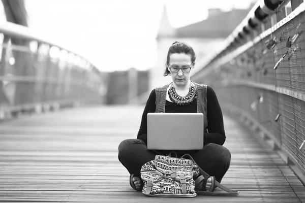 노트북을 들고 앉아 있는 젊은 여자 — 스톡 사진