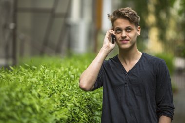 Genç adam cep telefonuyla konuşuyor.