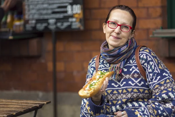 Kvinna äta Zapiekanka — Stockfoto