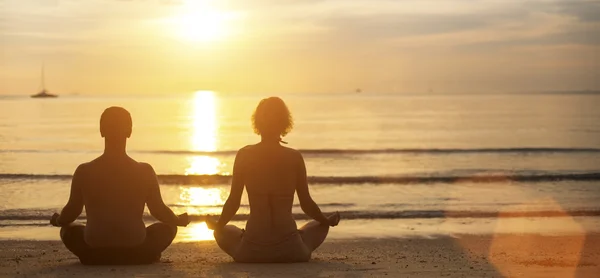 Man and woman yoga silhouettes — Stock Photo, Image