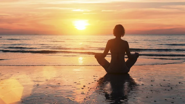 Silhuetten av en ung yoga kvinna — Stockfoto