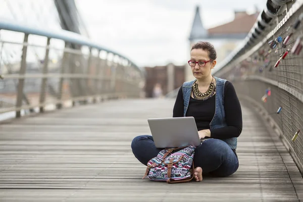 Young woman uses a laptop — Stock Photo, Image