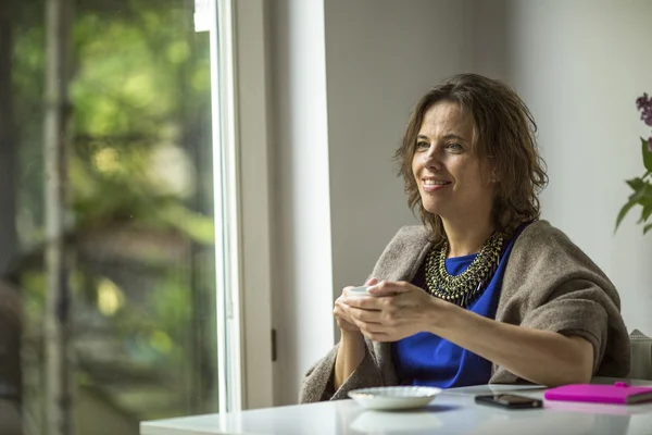 Woman sits in front of the window — Stock Photo, Image