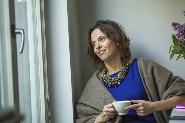 Woman looks out the window — Stock Photo, Image