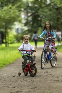 Little boy with sister ride bikes