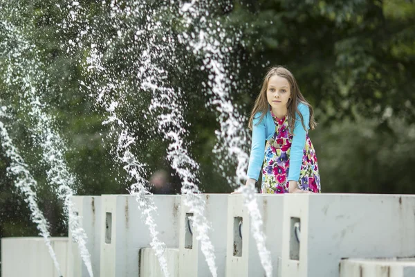 Kleines süßes Mädchen am öffentlichen Brunnen. — Stockfoto