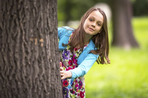 Lilla flickan bakom träd — Stockfoto