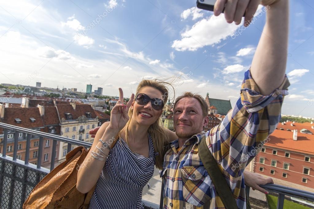 Young couple taking selfies on smartphone