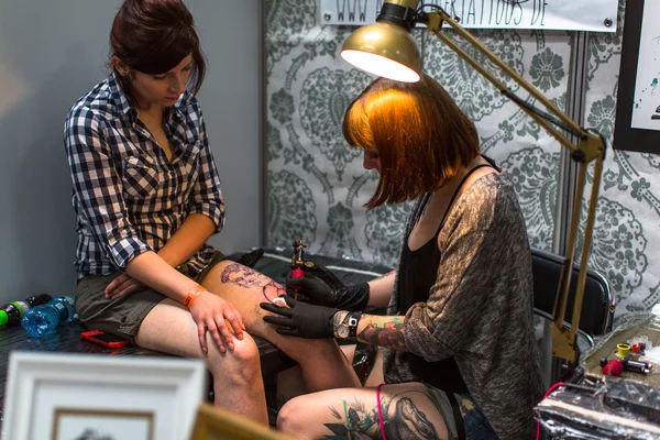 People make tattoos at Tattoo Convention — Stock Fotó