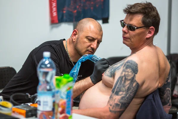 People make tattoos at Tattoo Convention — стокове фото