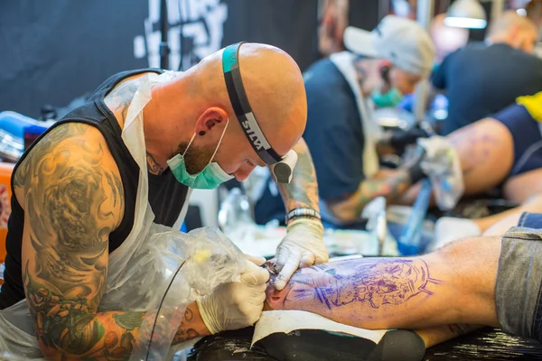 As pessoas fazem tatuagens na Convenção de Tatuagem — Fotografia de Stock