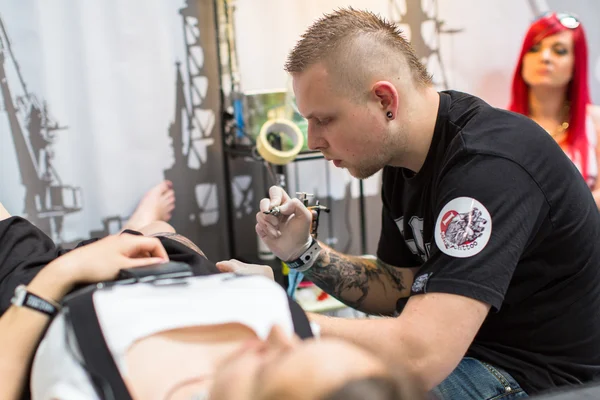 As pessoas fazem tatuagens na Convenção de Tatuagem — Fotografia de Stock