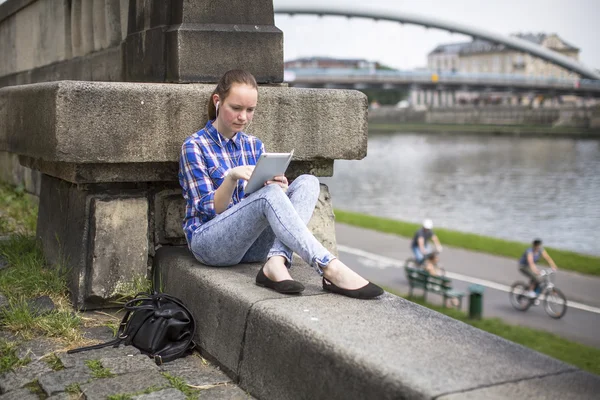 Девочка-подросток сидит с планшетом — стоковое фото