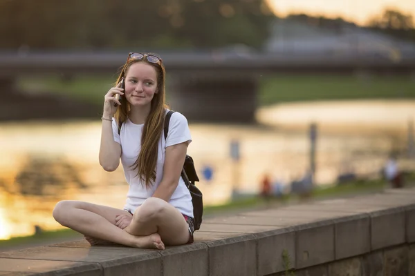 Ung flicka talar i mobiltelefon — Stockfoto