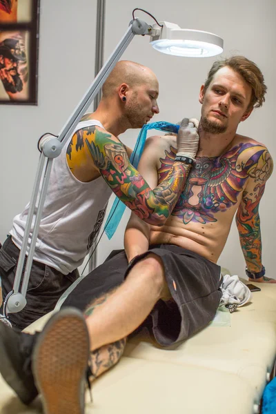 As pessoas fazem tatuagens na Convenção de Tatuagem — Fotografia de Stock