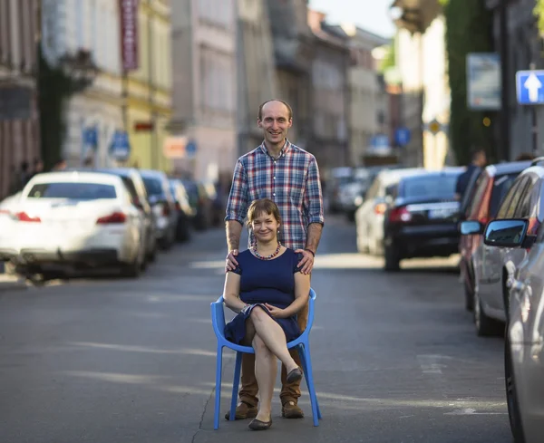 Young woman sits on chair with man — Stock fotografie