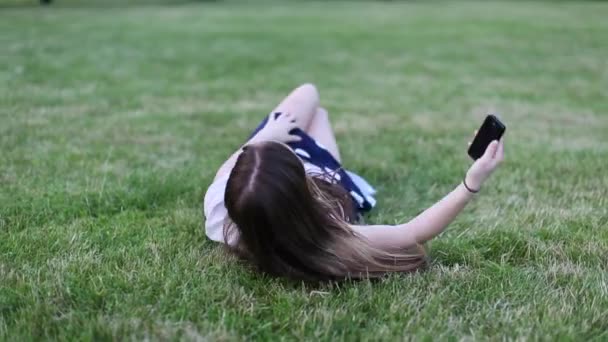 Young beautiful girl lying on grass — Stock Video