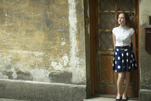 Cute teen girl stands near door — Stock Photo, Image