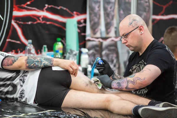 People make tattoos at Tattoo Convention — стокове фото