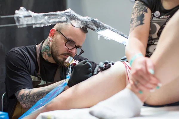 As pessoas fazem tatuagens na Convenção de Tatuagem — Fotografia de Stock