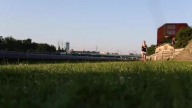 Yeşil çimenlerin üzerinde koşan koşucu kız