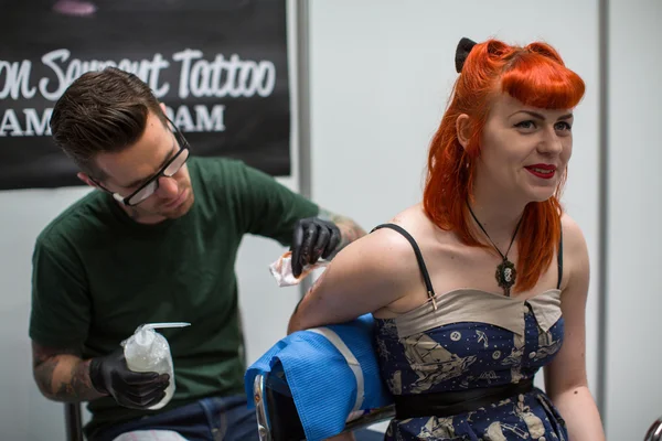 As pessoas fazem tatuagens na Convenção de Tatuagem — Fotografia de Stock