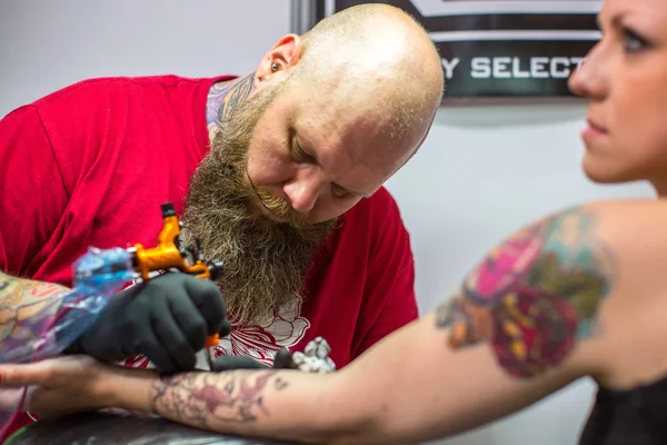 As pessoas fazem tatuagens na Convenção de Tatuagem — Fotografia de Stock