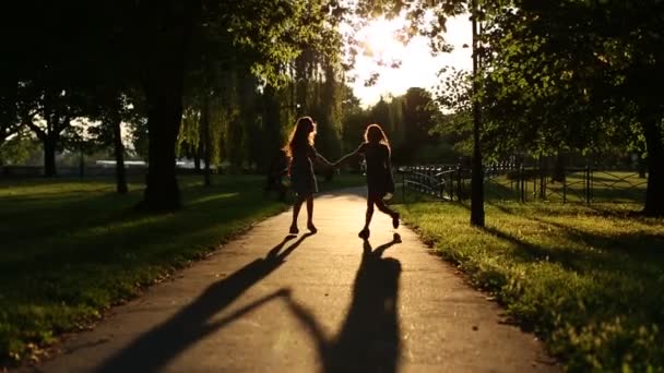 Silhuetter av två tjejer går — Stockvideo